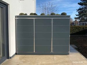 Ein moderner Gartenschrank mit Pflanzen auf dem Dach, steht an einer Hauswand.